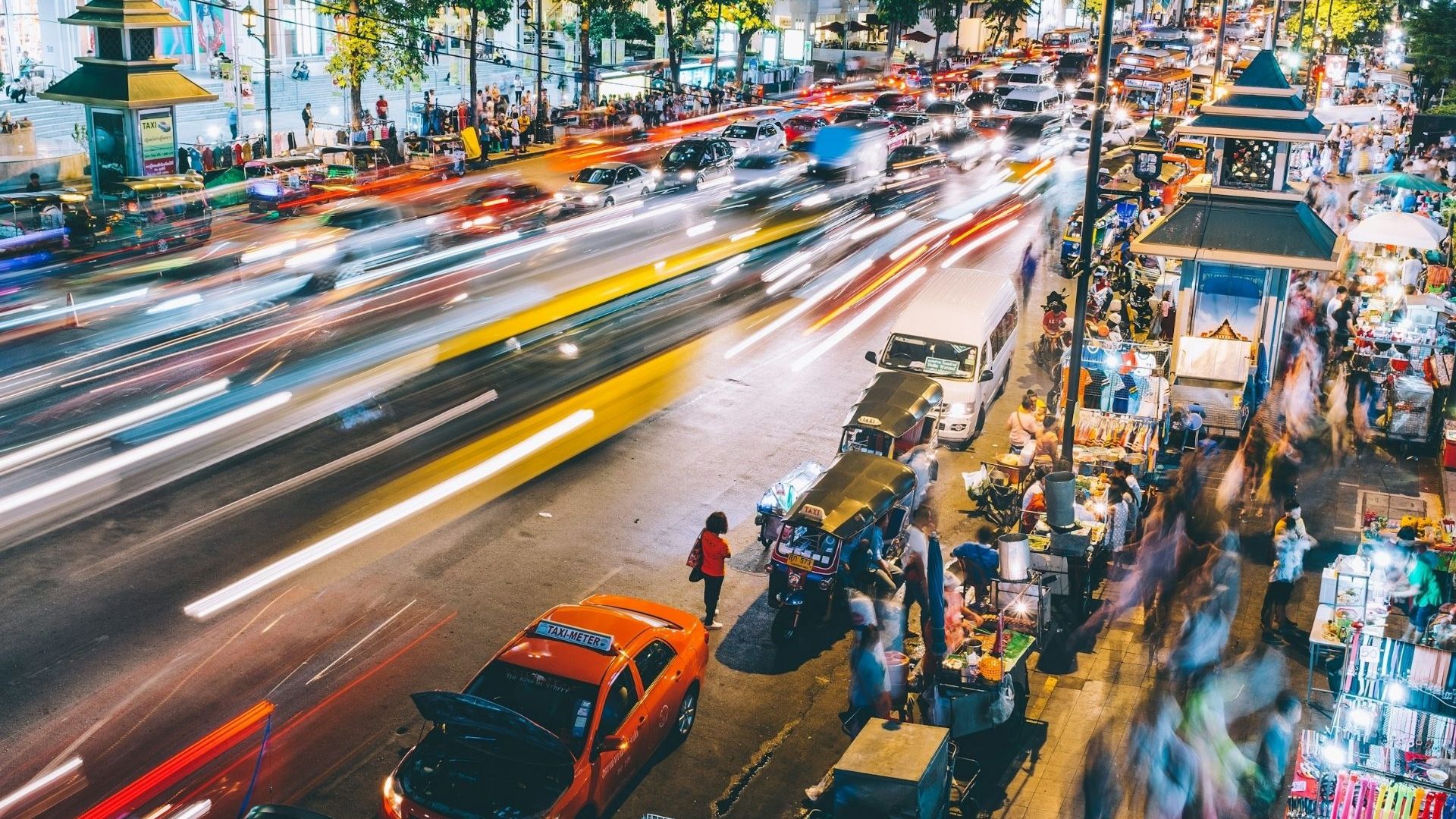 A blurred, busy street scene in Bangkok by night