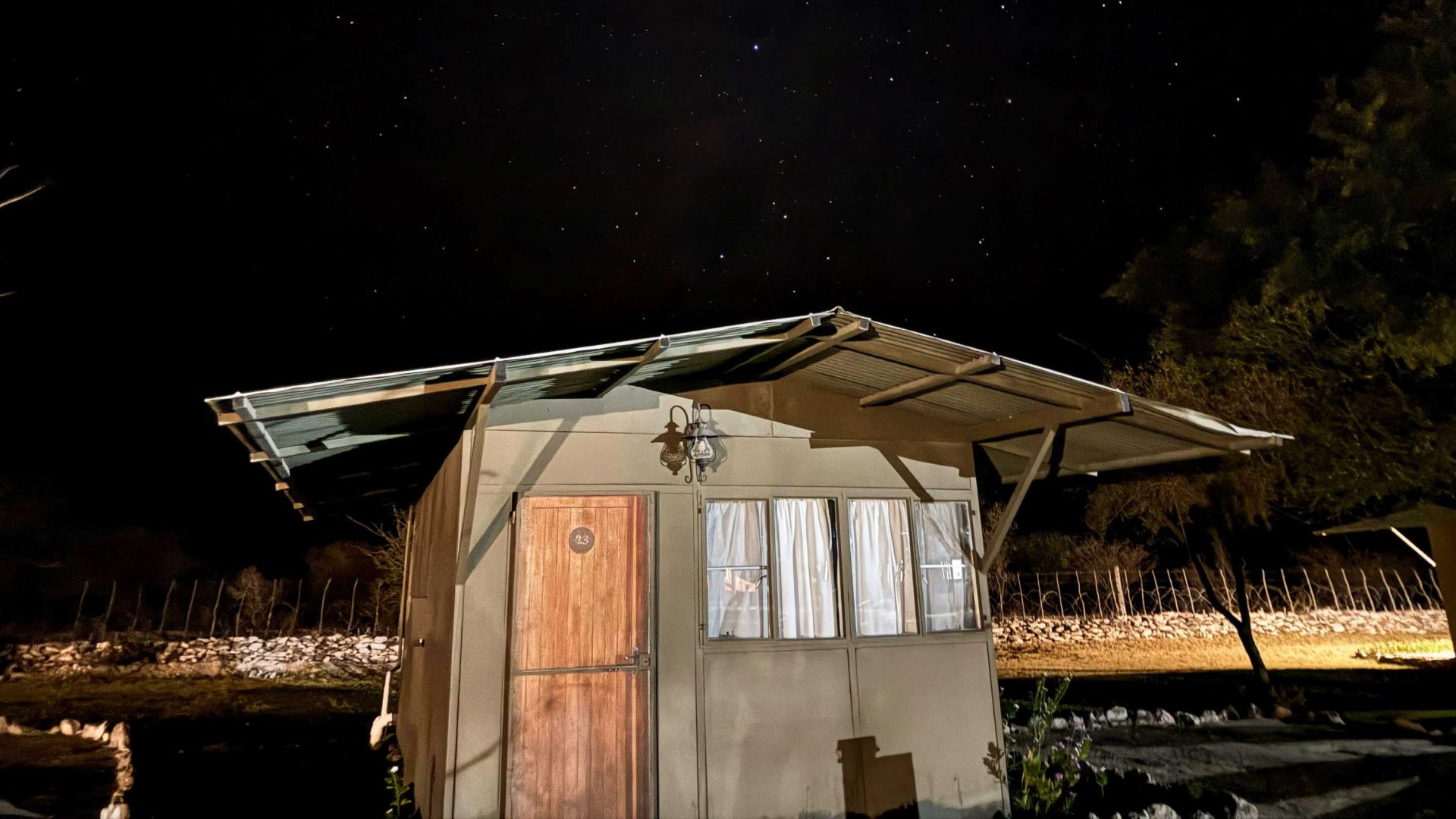 A cabin with a starry night sky above it.
