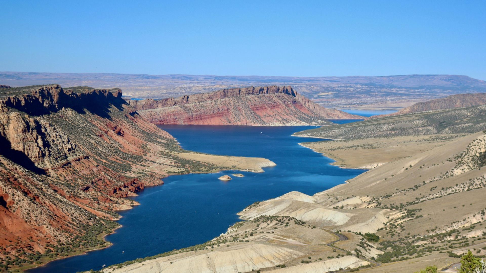 Birds-eye view of canyon landscape with blue water.