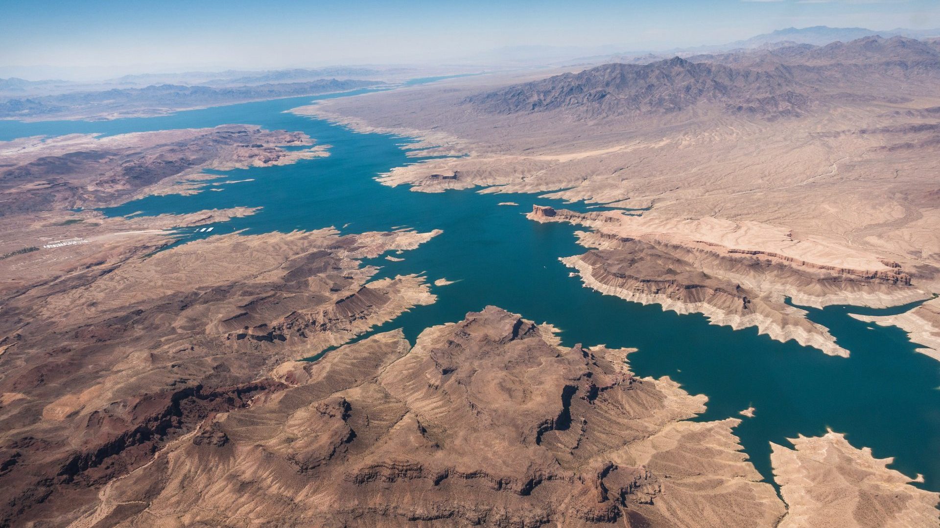 Aerial view of desert landscape and blue reservoir