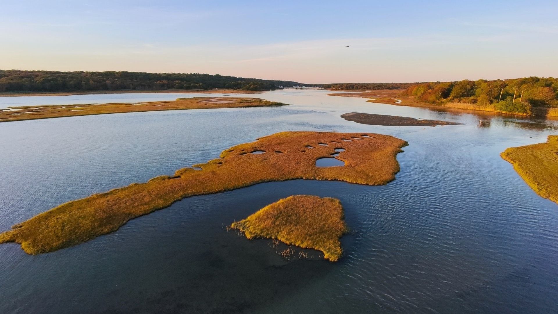 Aerial view of grassy sandbars in the Narrow River in Narragansett, Rhode Island, just before sunset.