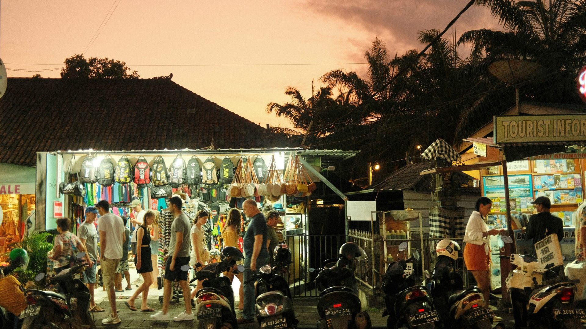 A crowd of tourists shop at sunset