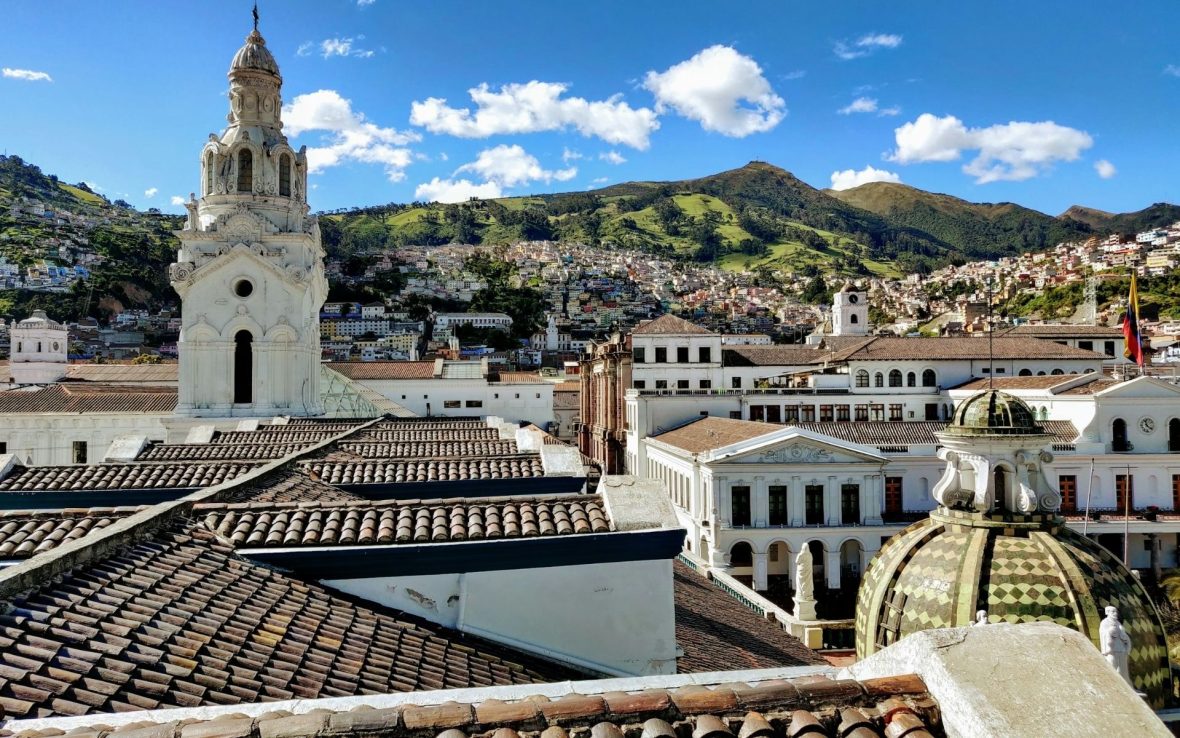 A rooftop view over Quito's spires, buildings and hills in the distance