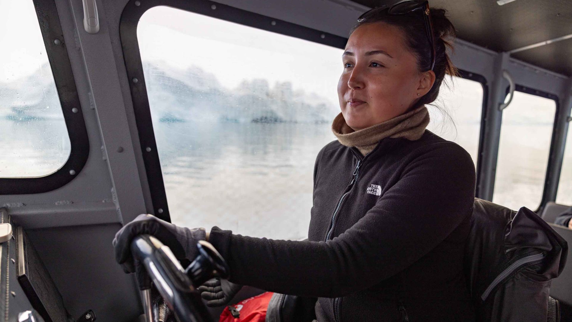 A woman drives a boat.