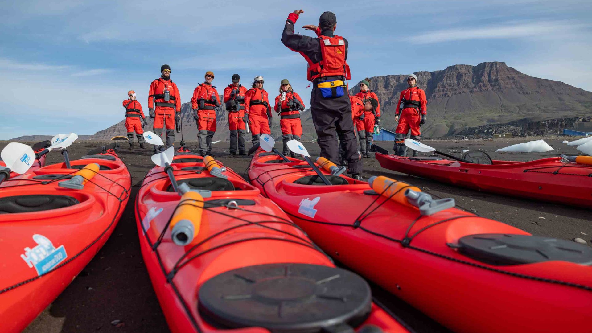 People dressed in red prepare to go kayaking.
