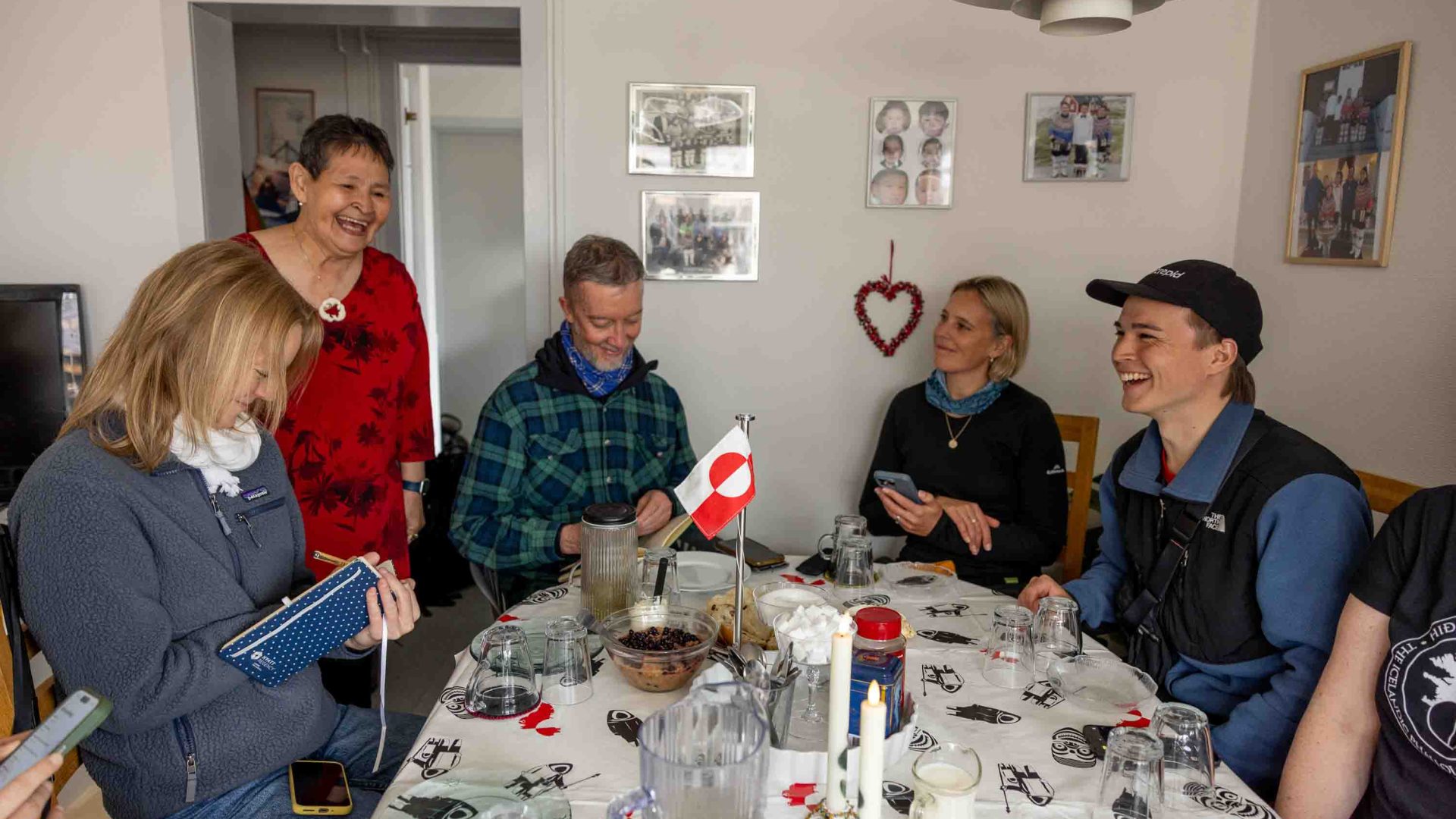 A group of people sit and enjoy a meal at a home.