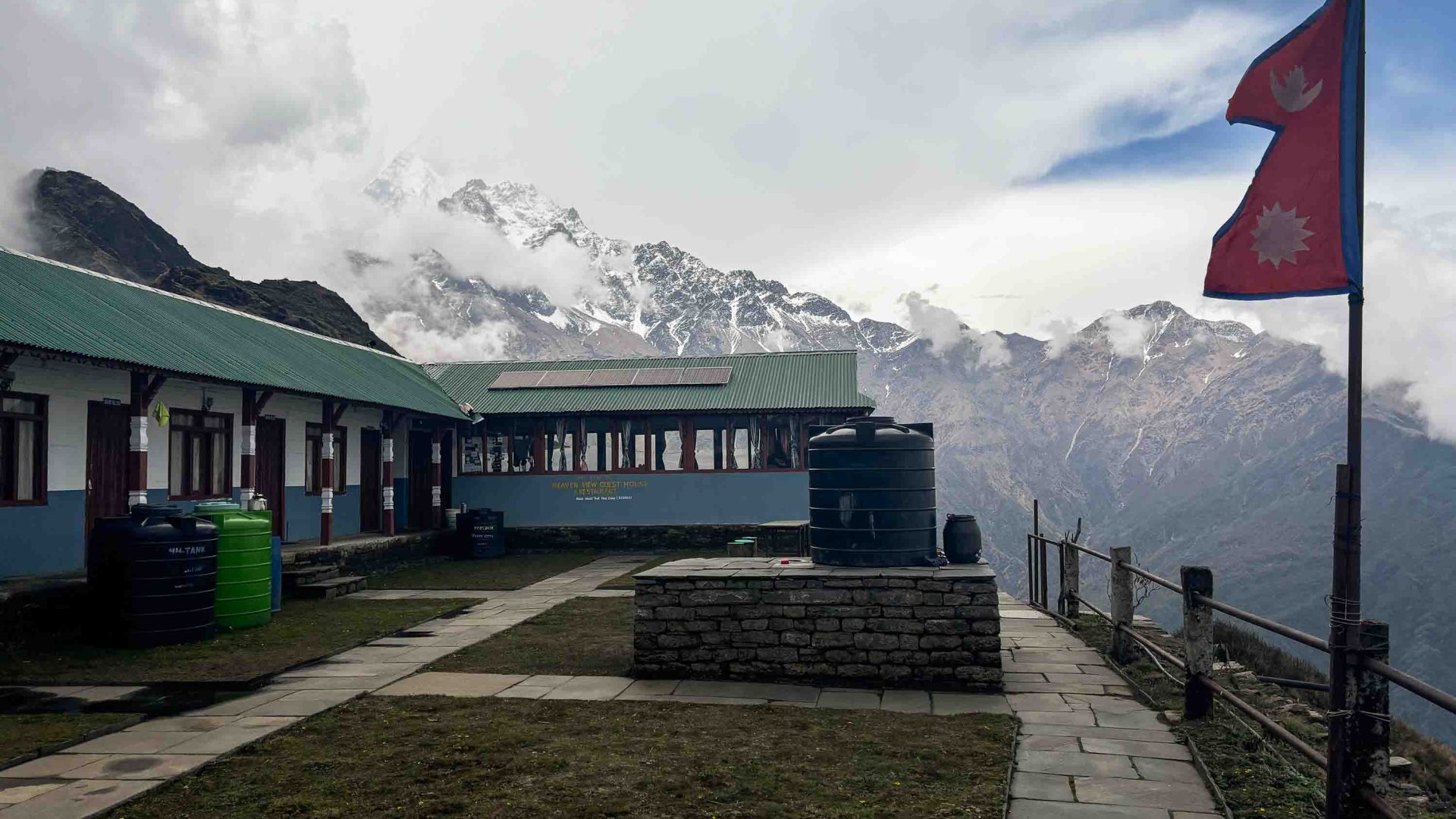 A teahouse flies a flag, with mountains in the background.