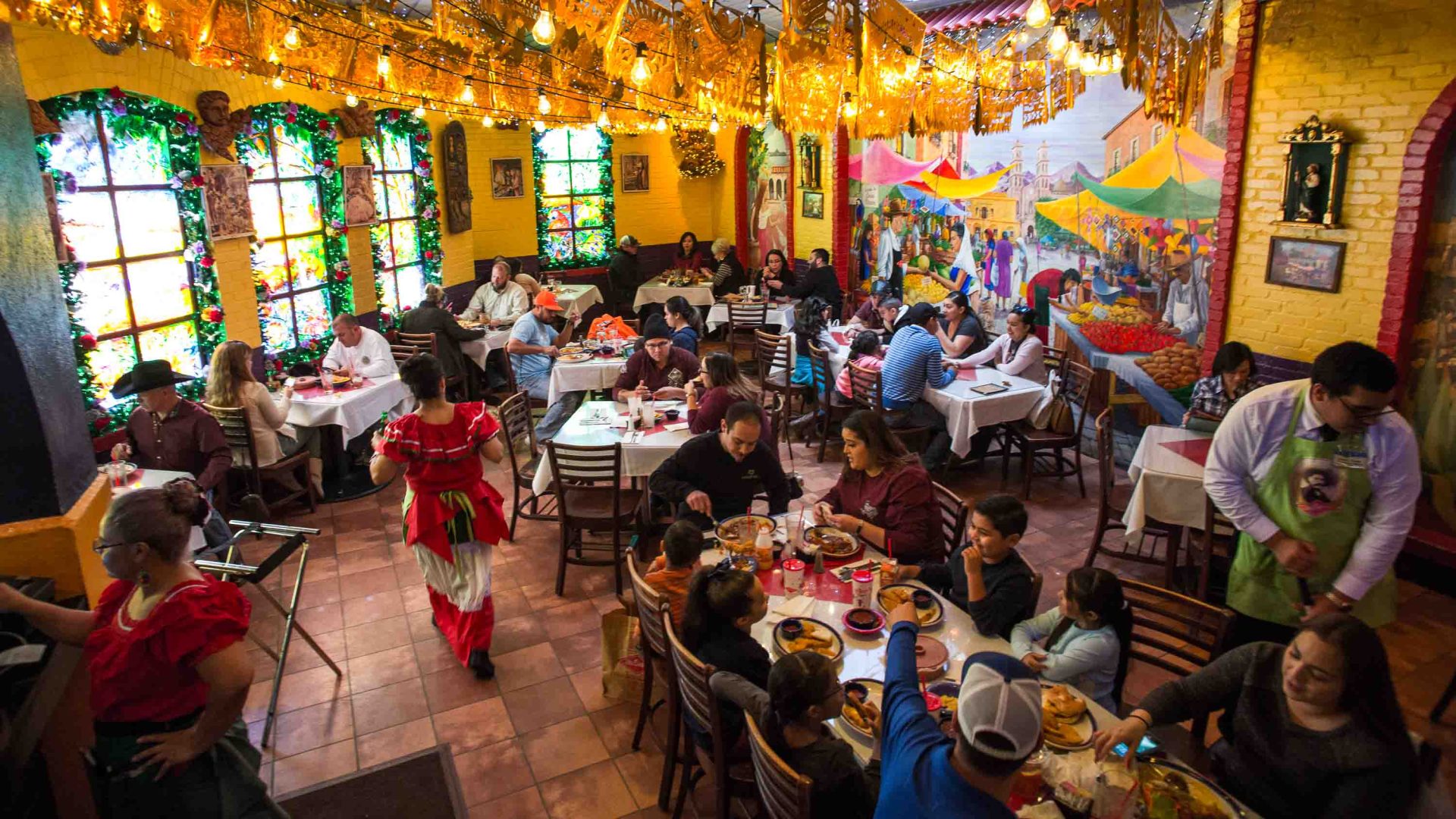 Diners enjoy a meal at Mi Tierra, below dazzling gold bunting.