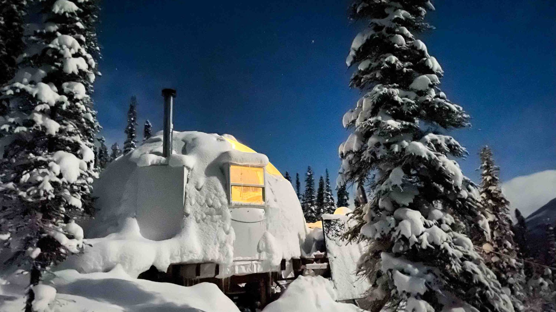 An igloo surrounded by snow.