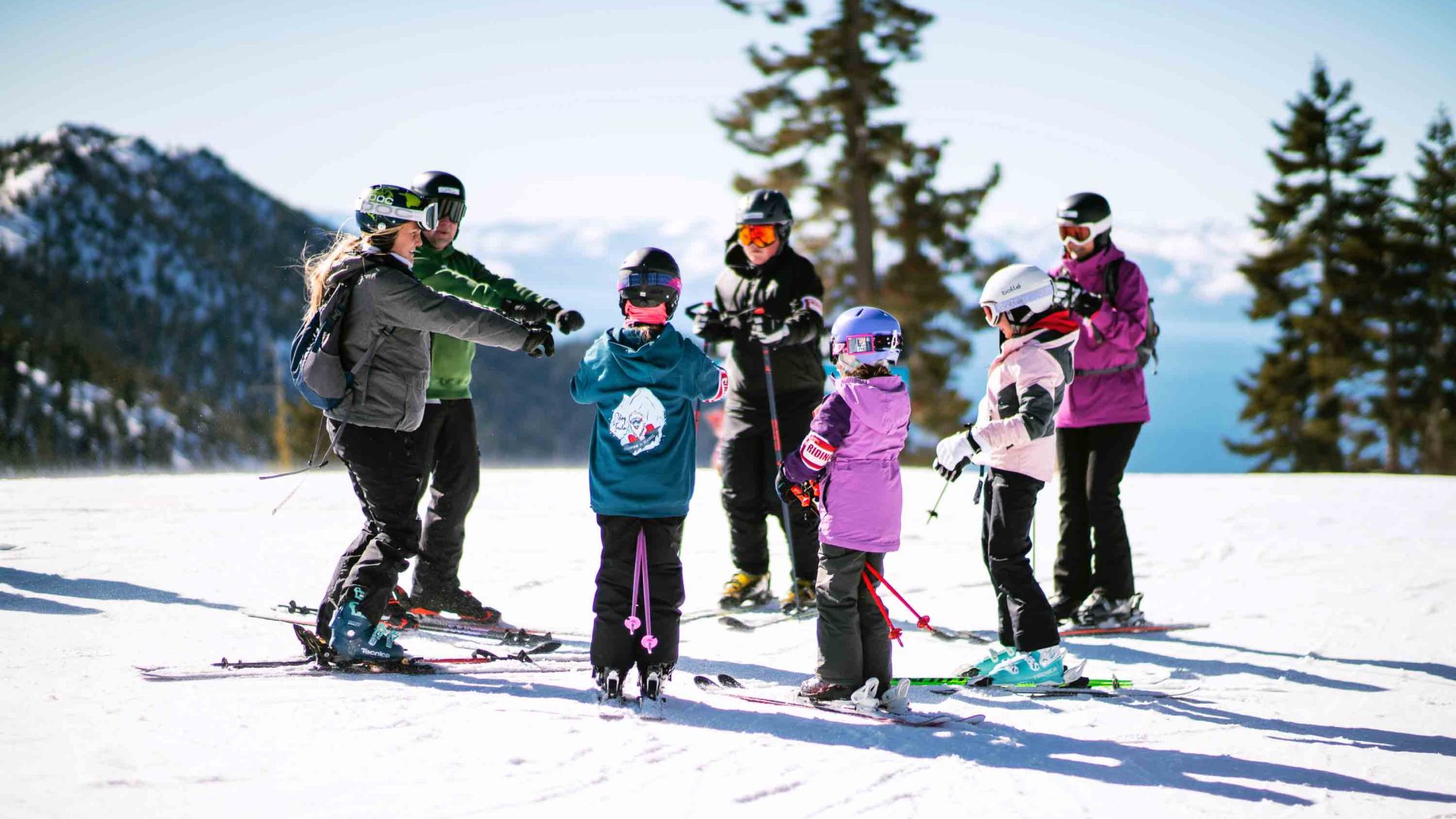 Kids on a mountain with snowboards.