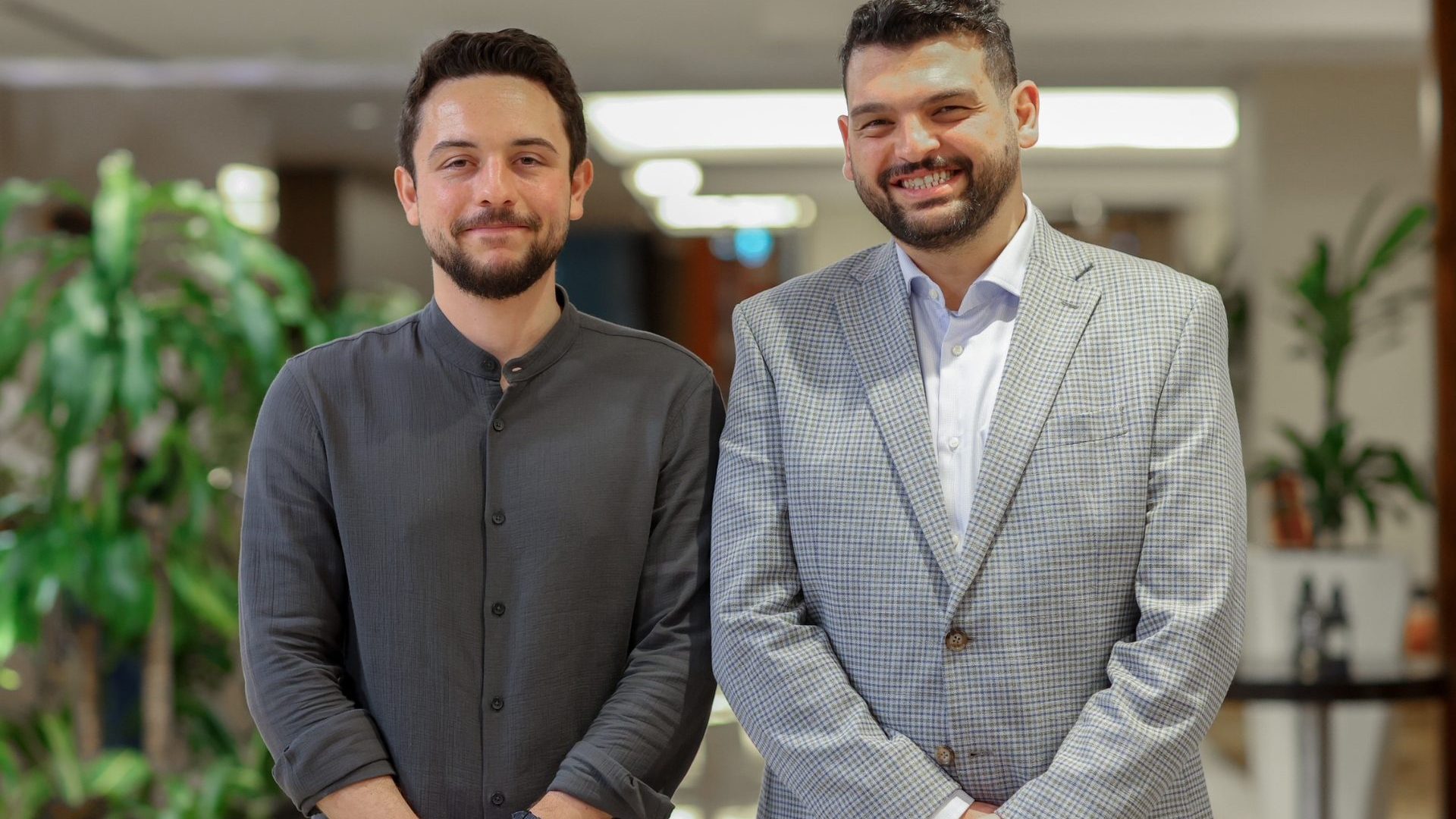 Two men smile at the camera.