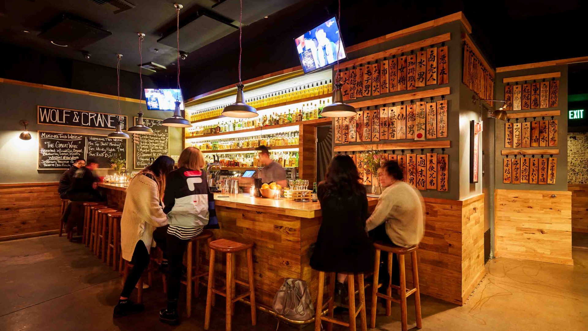 People sit around a bar in low light.