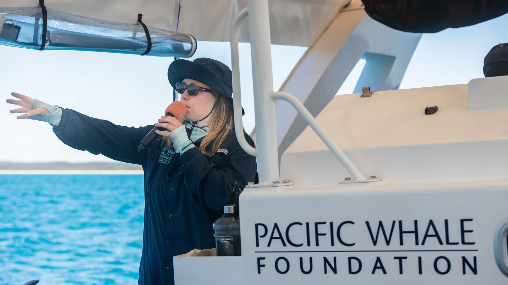 A female guide talks into a microphone as pointing something out.