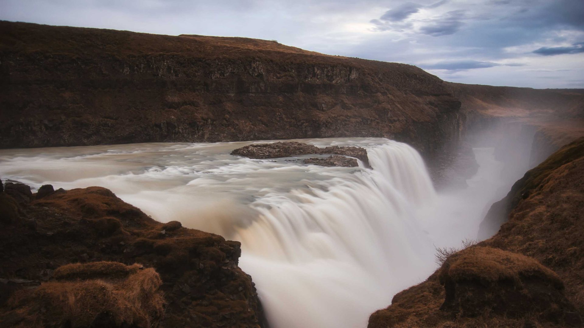 A waterfall drops over a cliff.