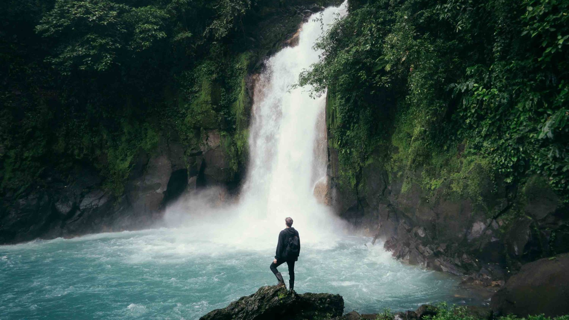 A person looks out at a waterfall.