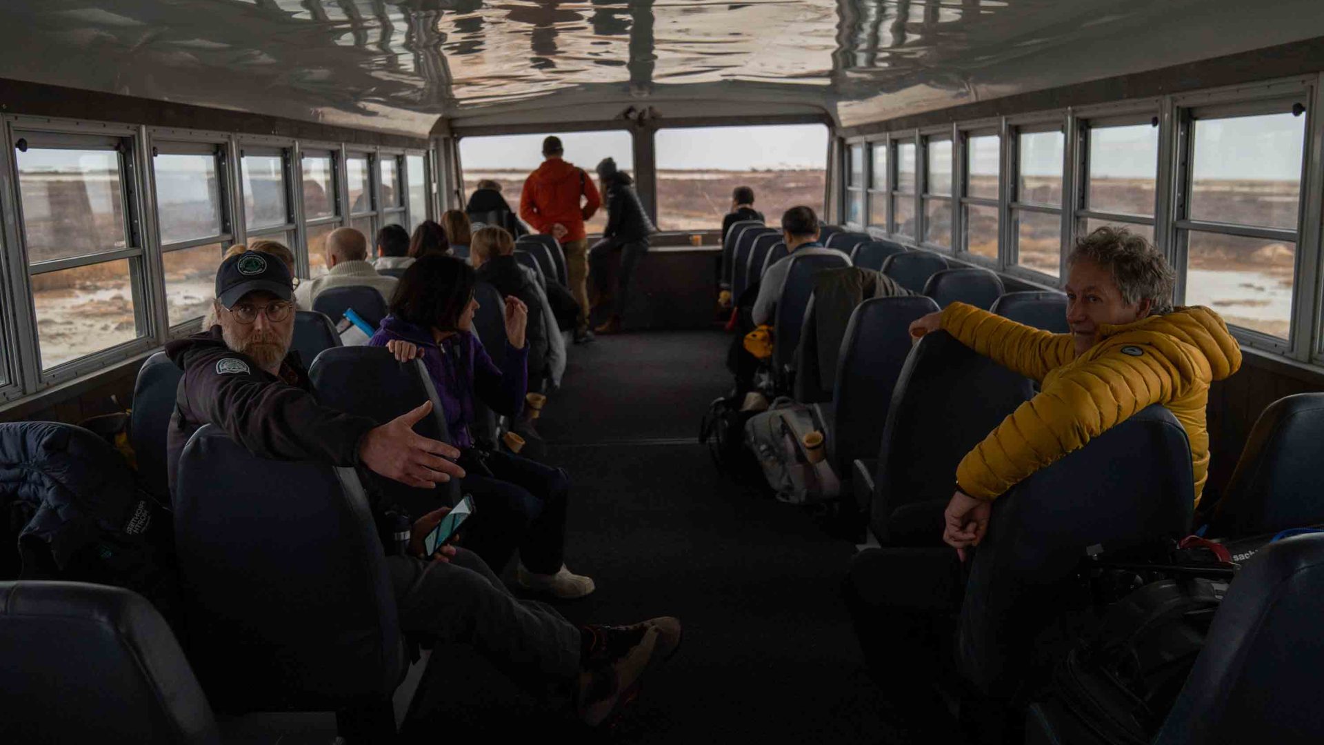 A guide on a bus full of people.