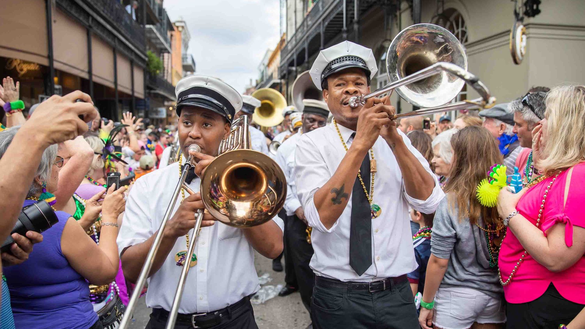 Musicians in the street, flanked by people.
