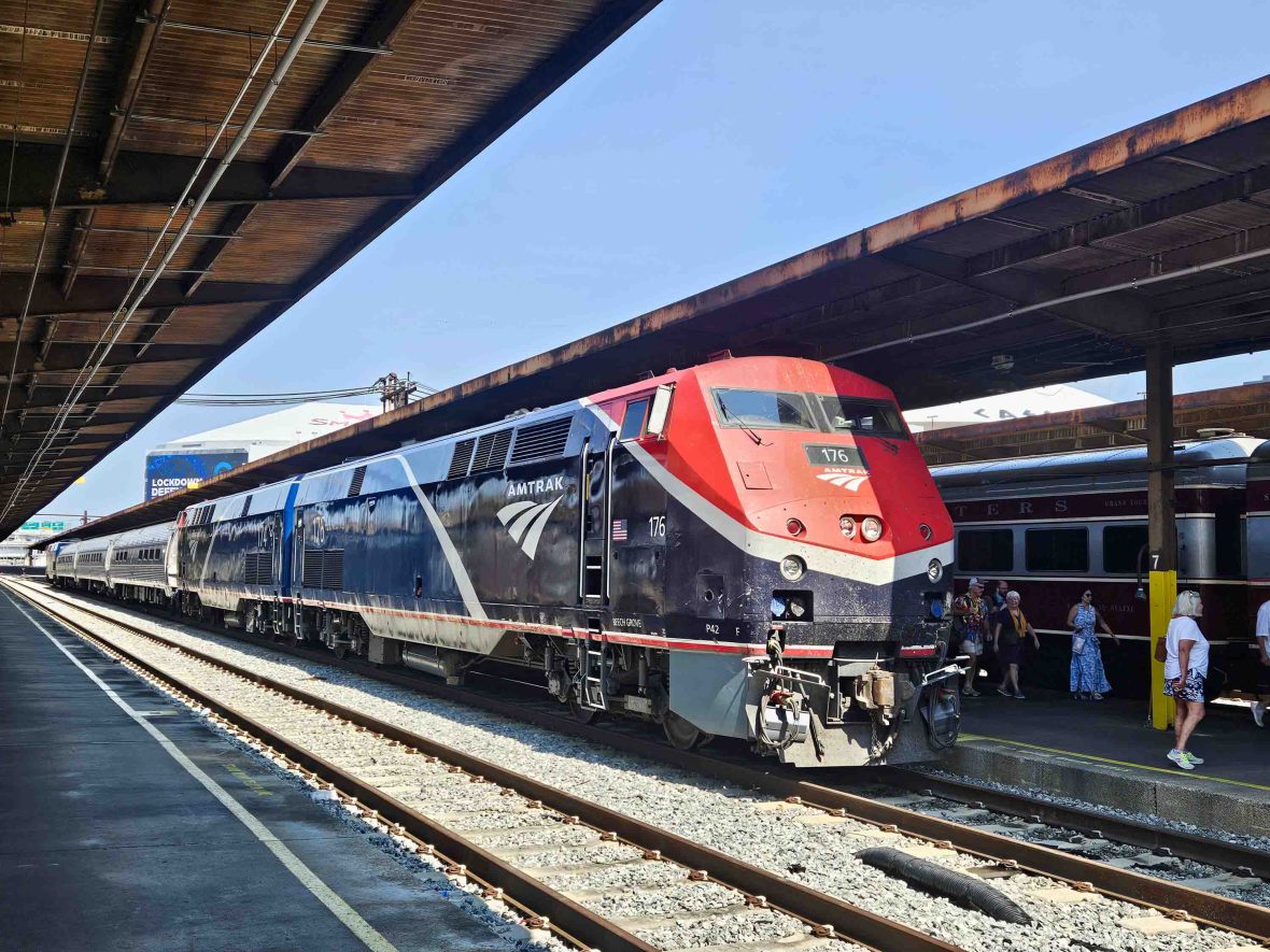 A red and black train at a train station platform.