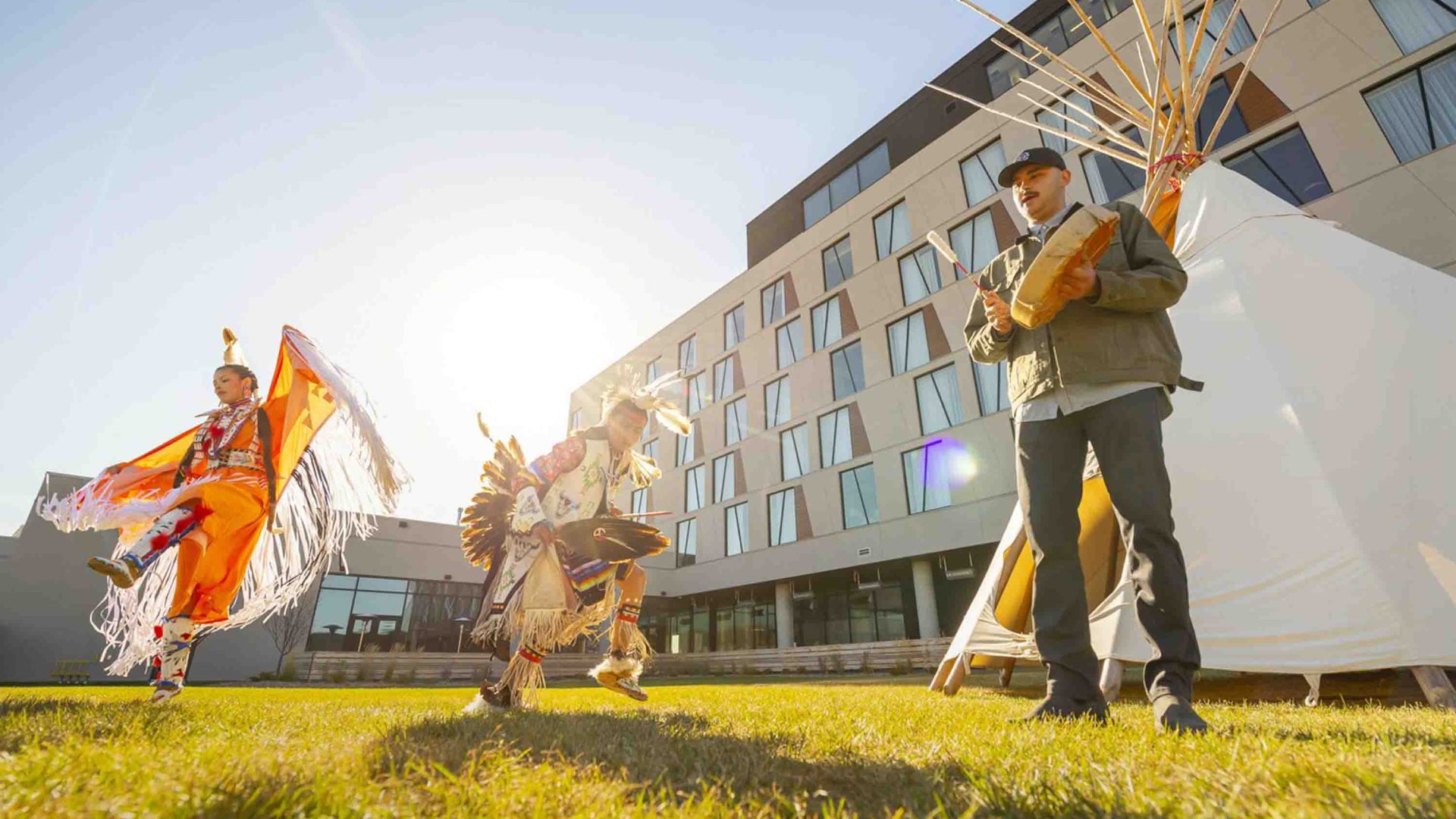 Indigenous performers outside a hotel.