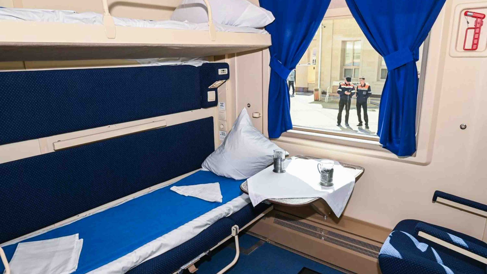 A sleeper carriage with bunk beds and a small table.