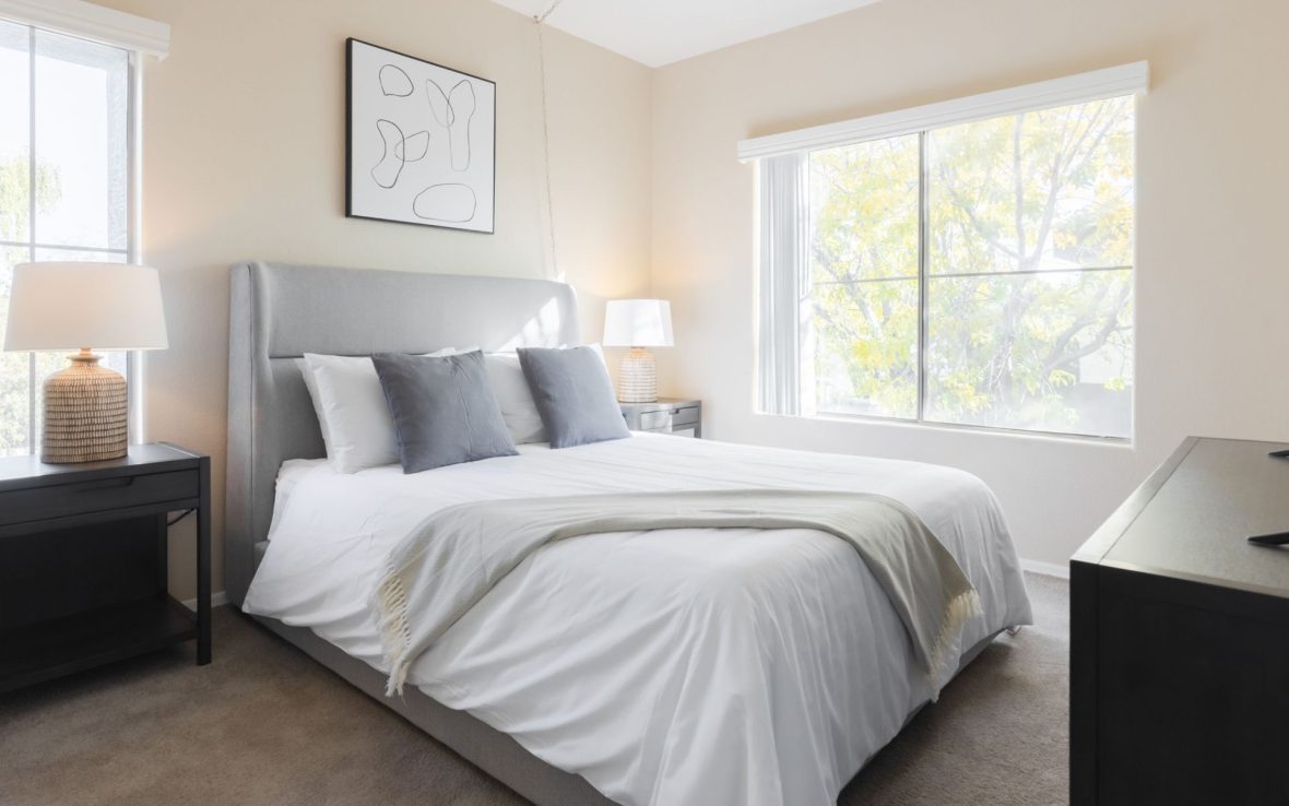 A bed in a sunny bedroom