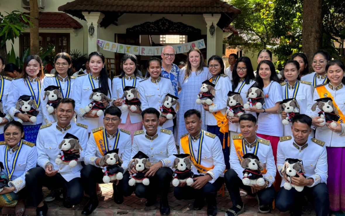Group of newly graduated university students pose for photo.