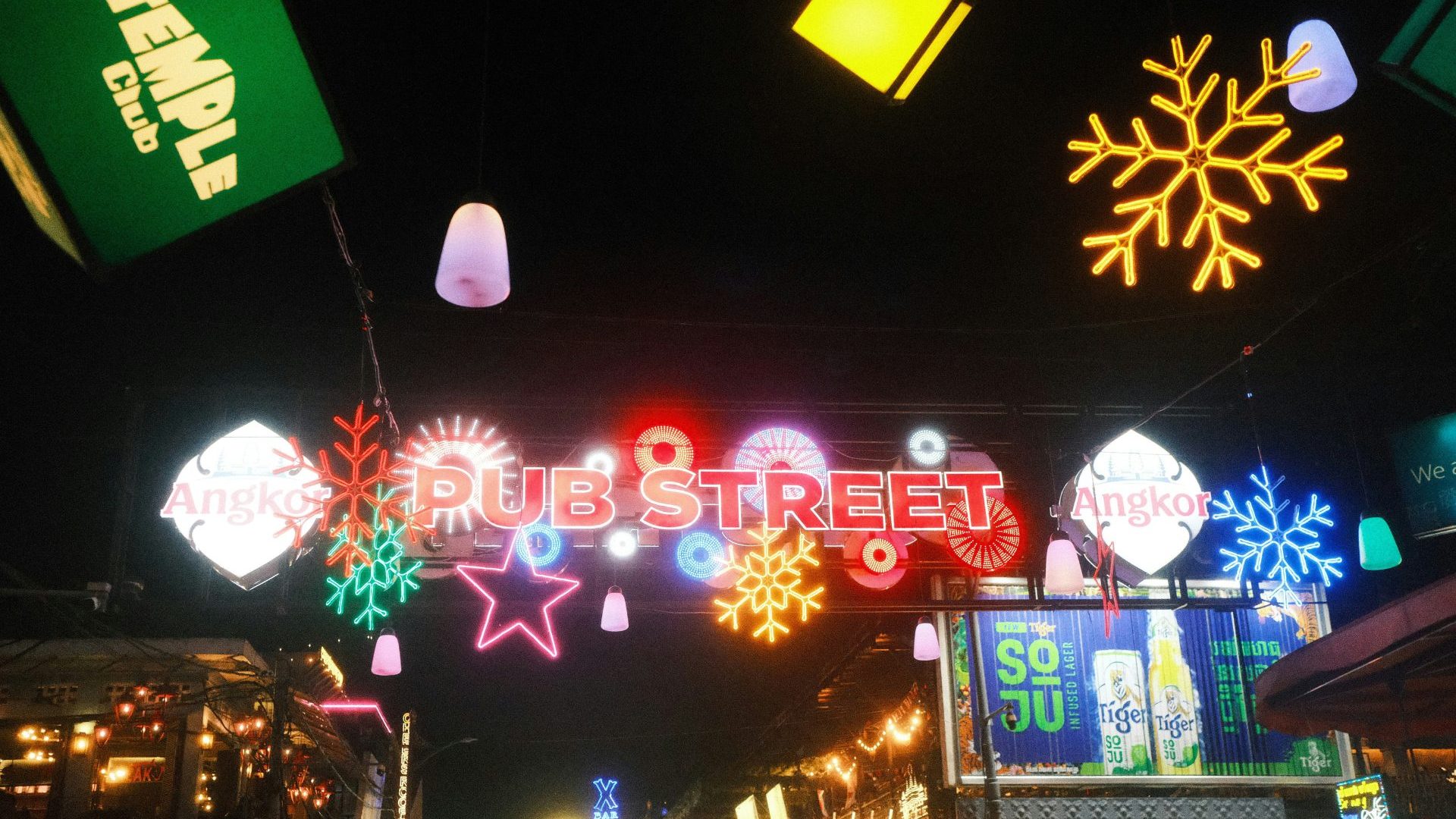 Neon lights reading 'Pub Street' lit against dark sky