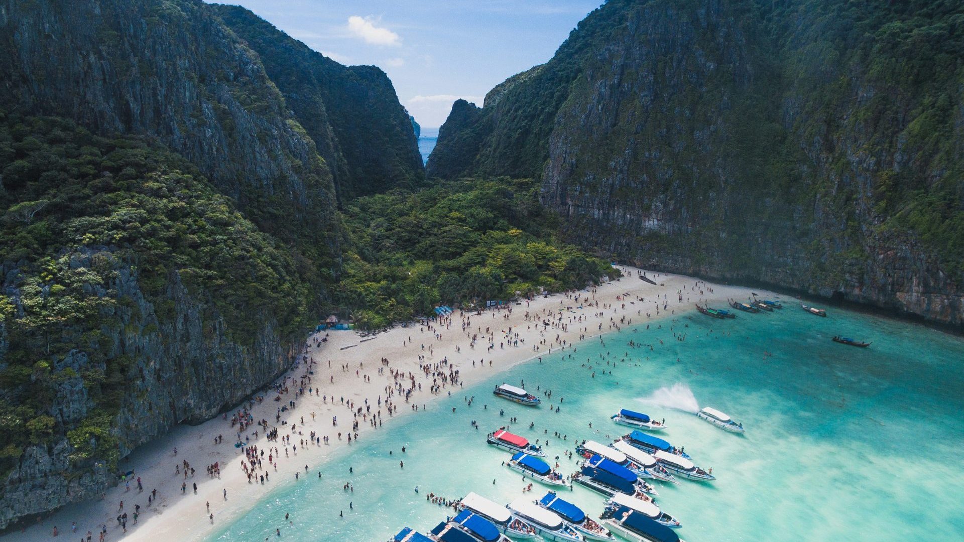 Beach packed with boats and people