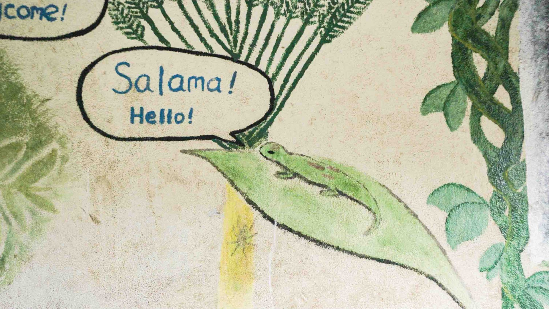 A school mural with a drawing of a gecko and the words "Salama! Hello!"