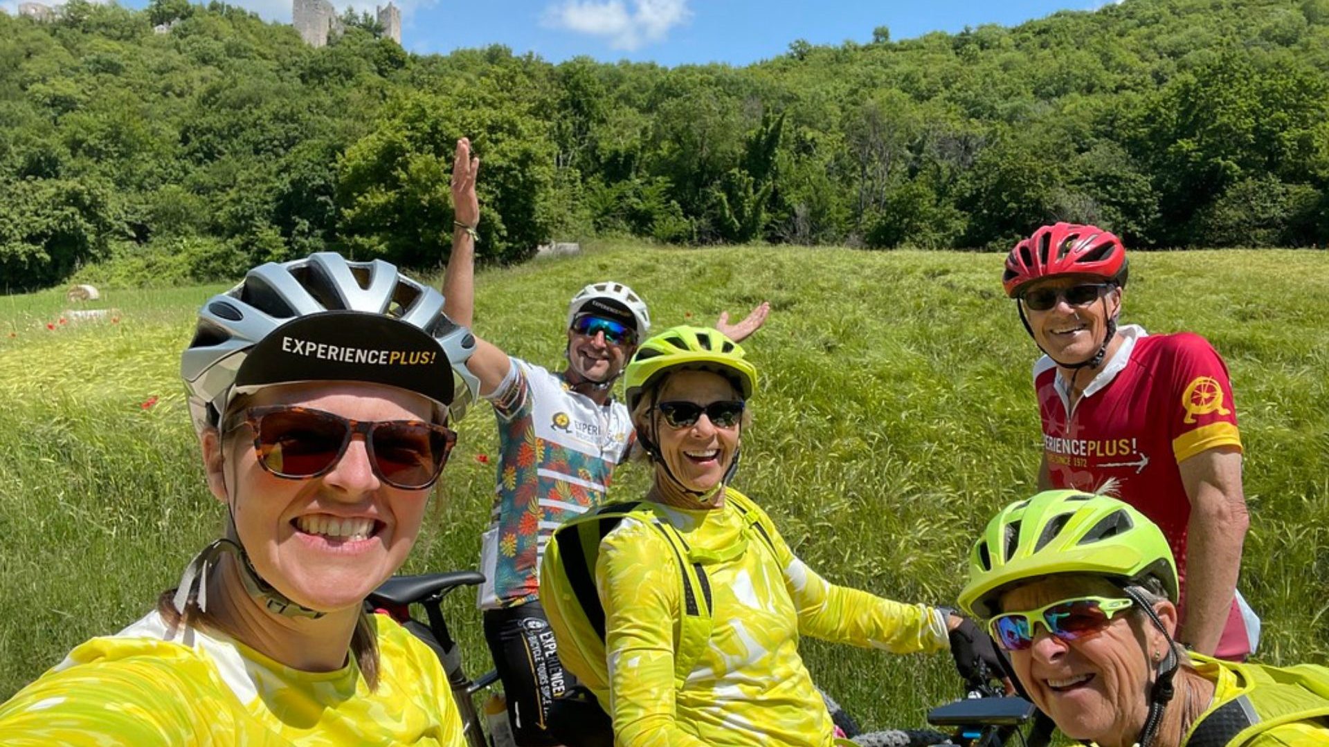 Group of cyclist smile for selfie wearing hi-vis riding shirts.