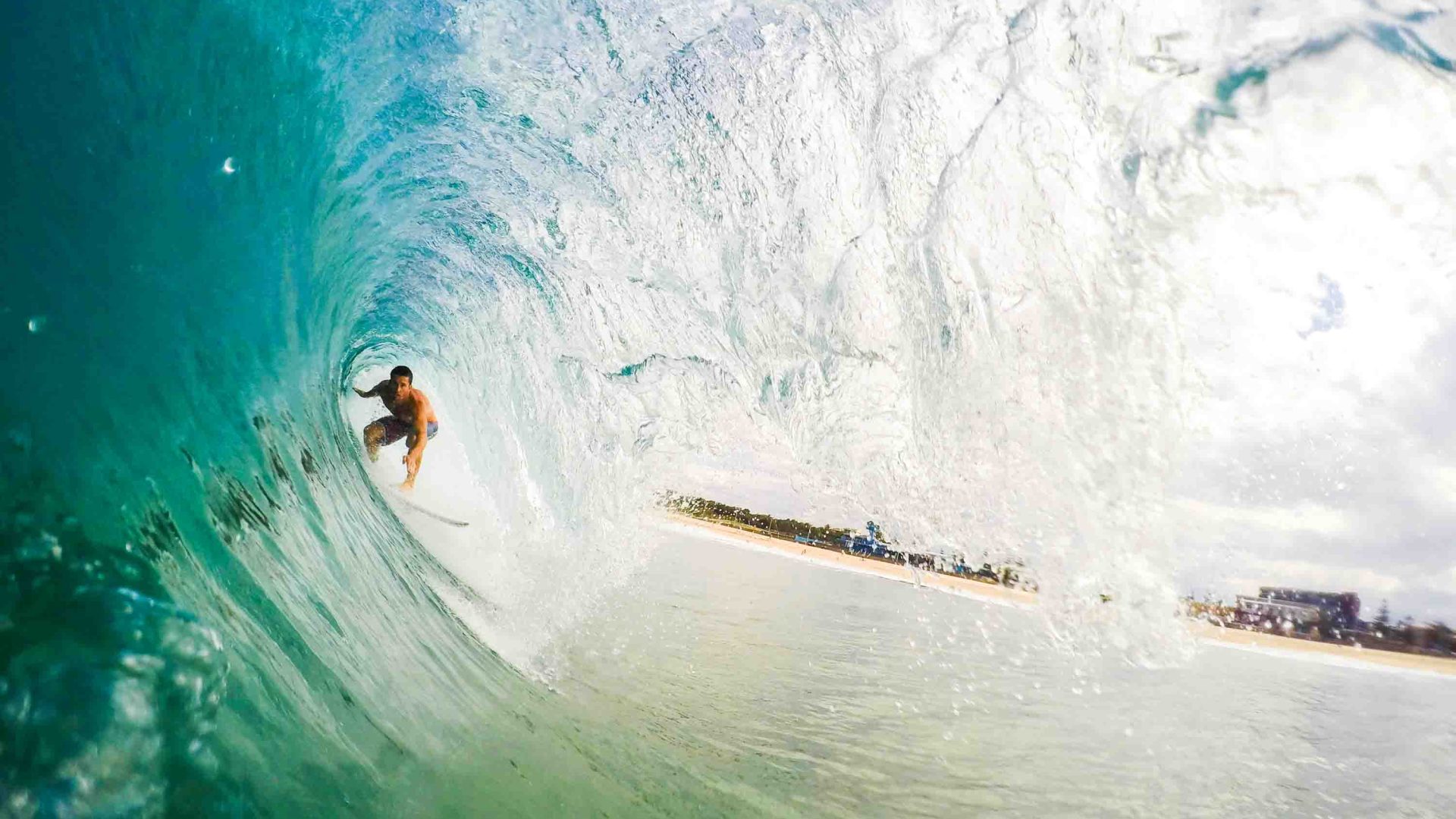 A person surfs a barrel - where they are inside the wave as it breaks over them.