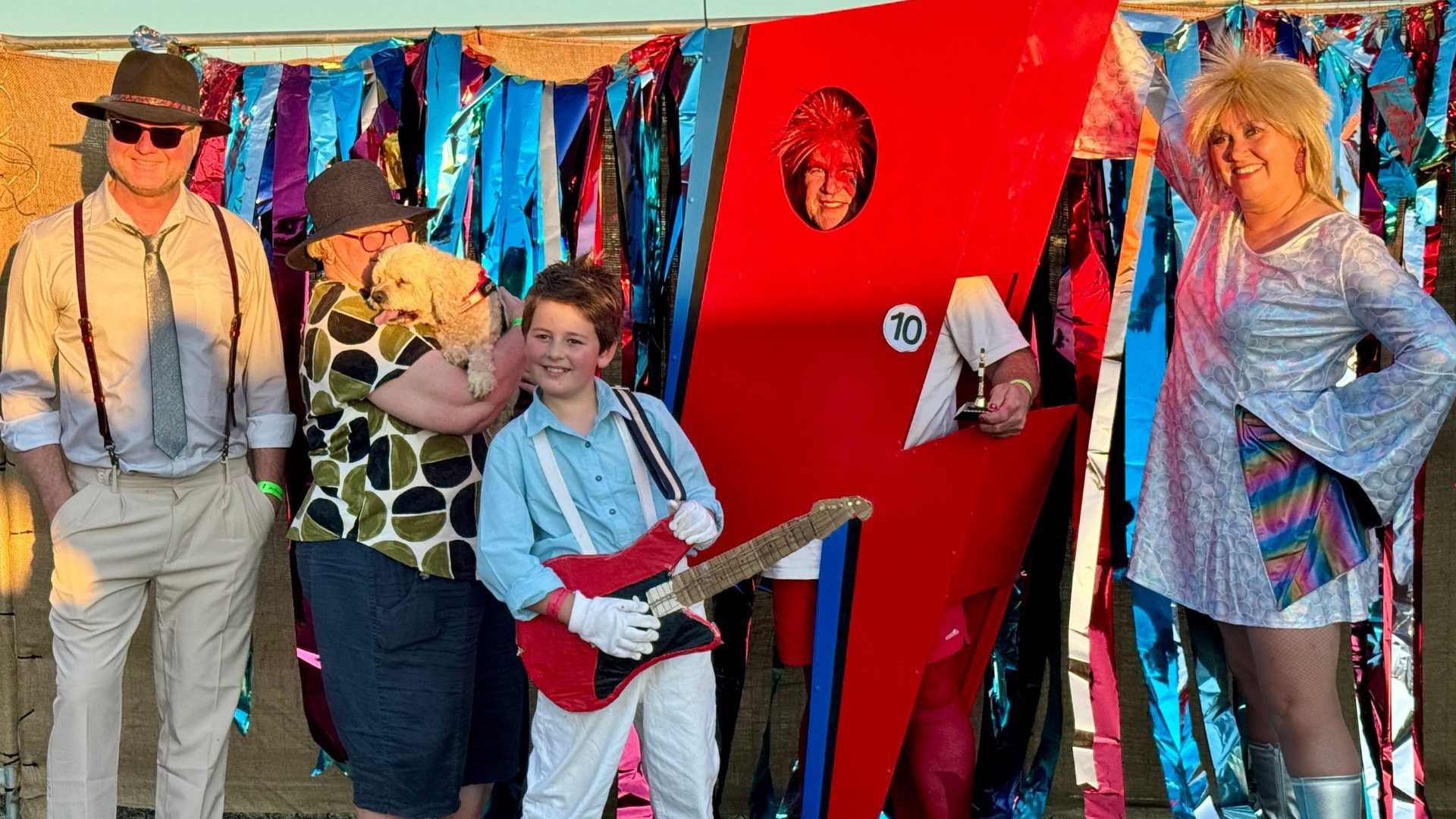 Group of people dresses as Bowie, including a man as a giant red lightning bolt.
