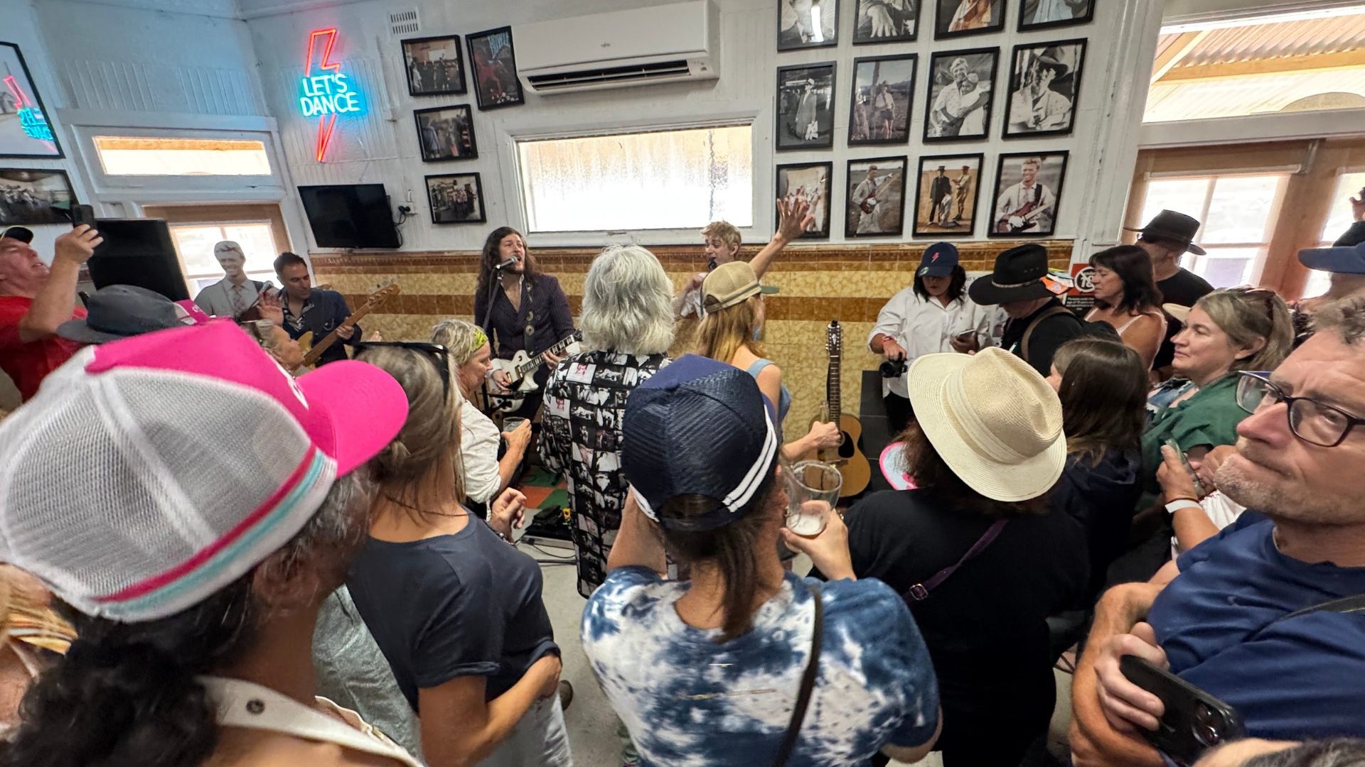 Group of people surround man playing guitar