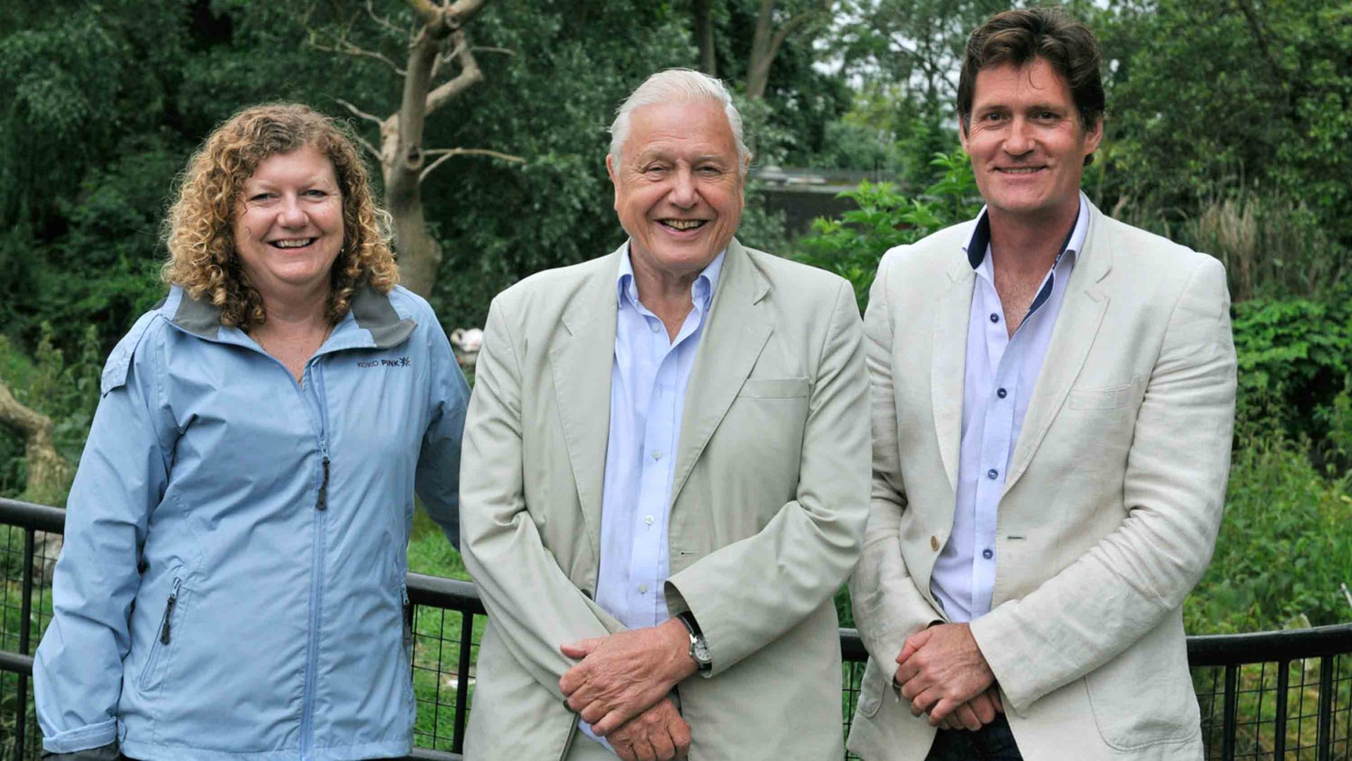 A woman and two men pose for a group portrait.