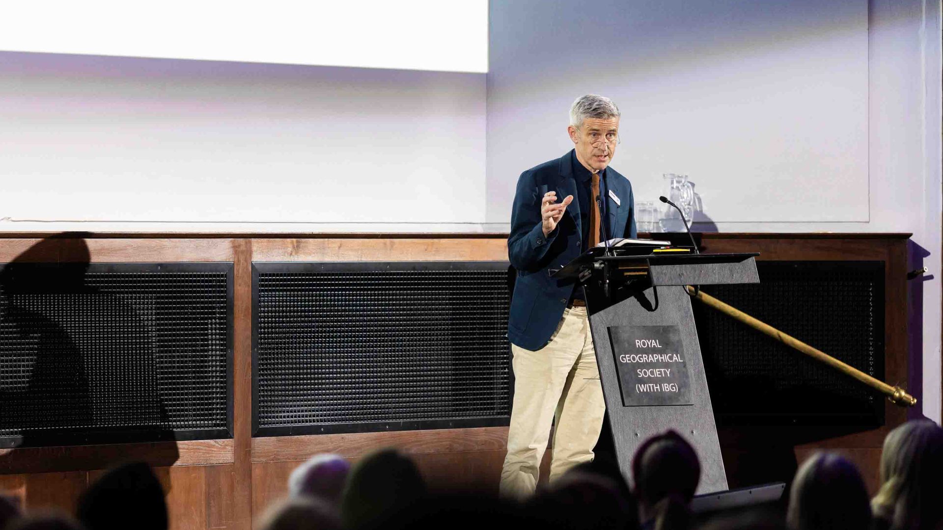 A man speaks at a lectern to an audience.