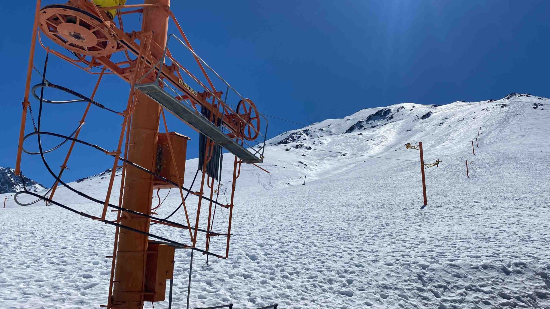 A disused drag lift on a snowy hill.