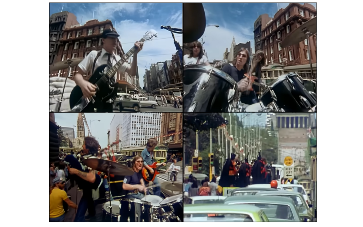 Band plays on flat bed of truck driving through city.