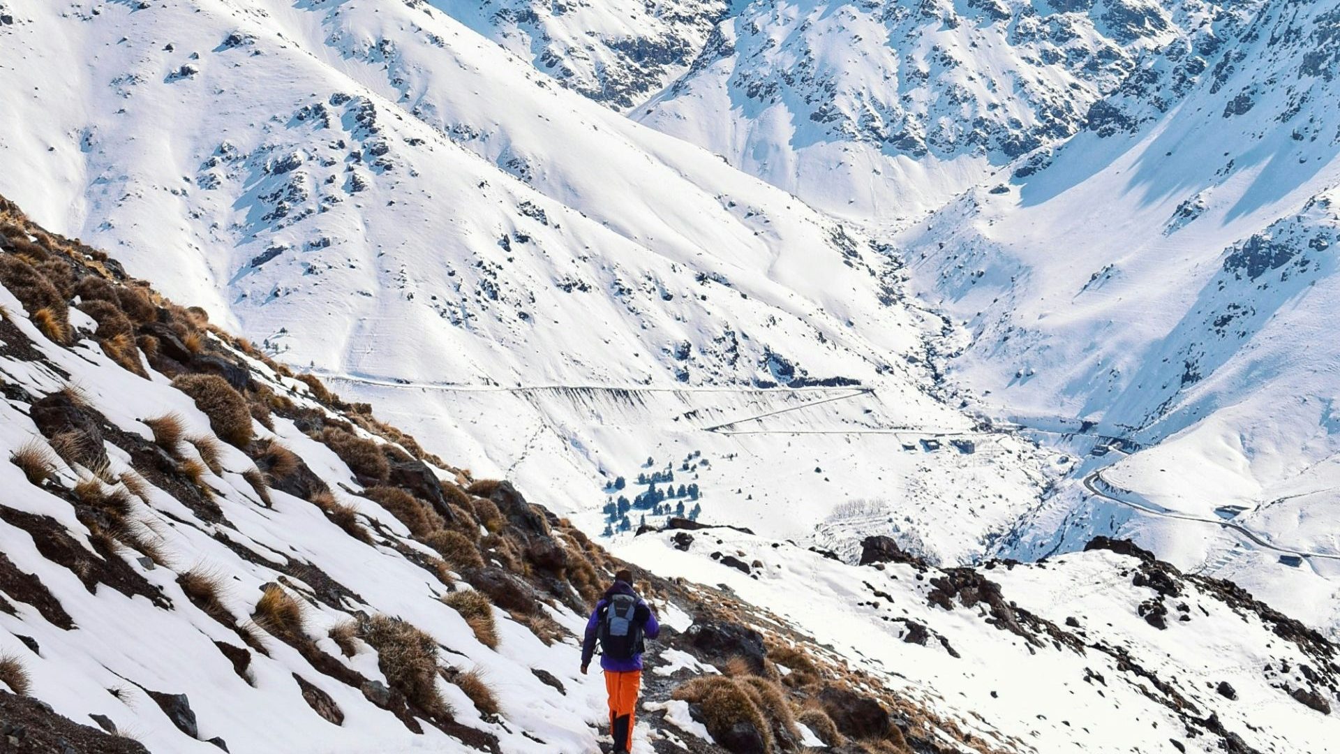 Hikers walking into snowy mountain range.