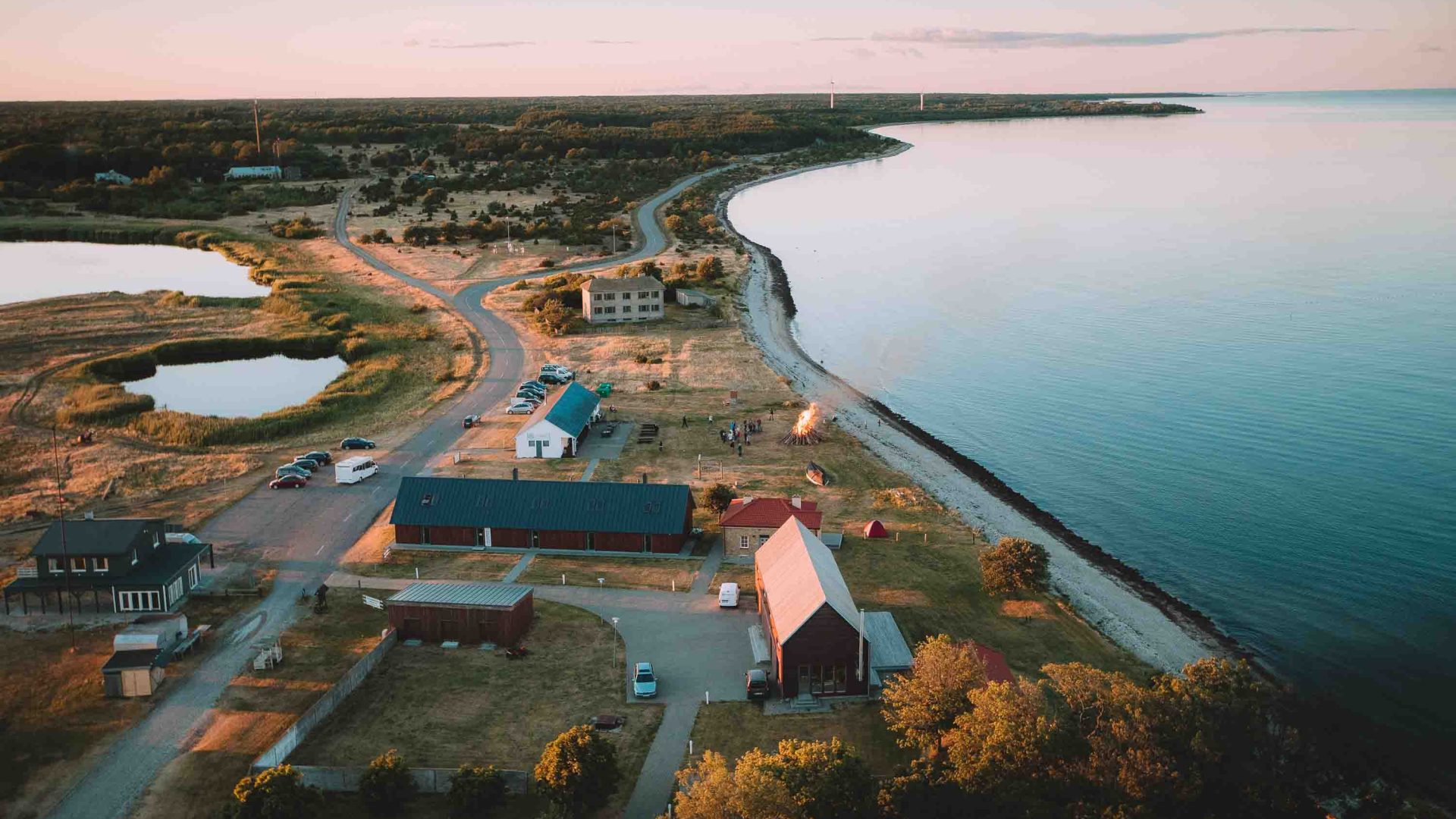 A view of houses in the middle of a peninsula with calm water on both sides.