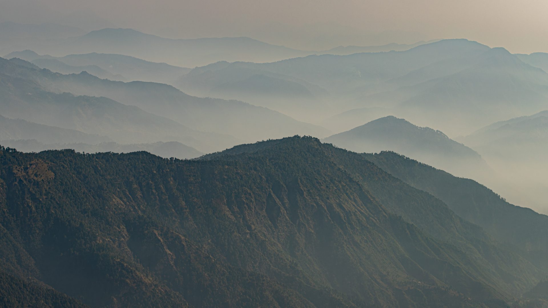 Mountains are shrouded in cloud as far as the eye can see.