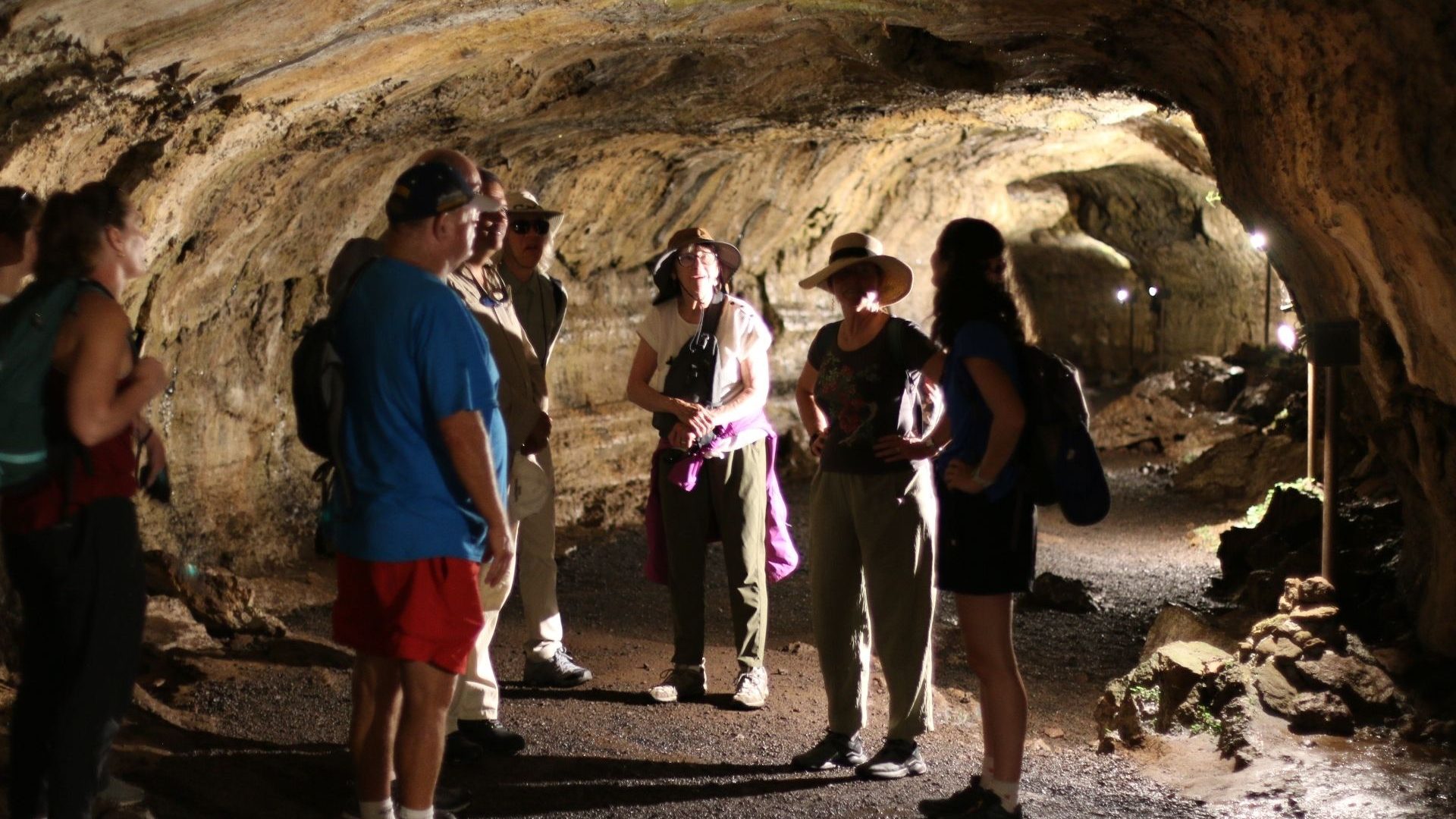 A group of people inside an underground lava tunnel