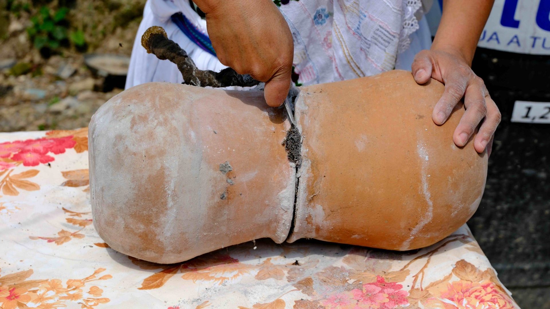 A close-up of someone opening up a clay pot