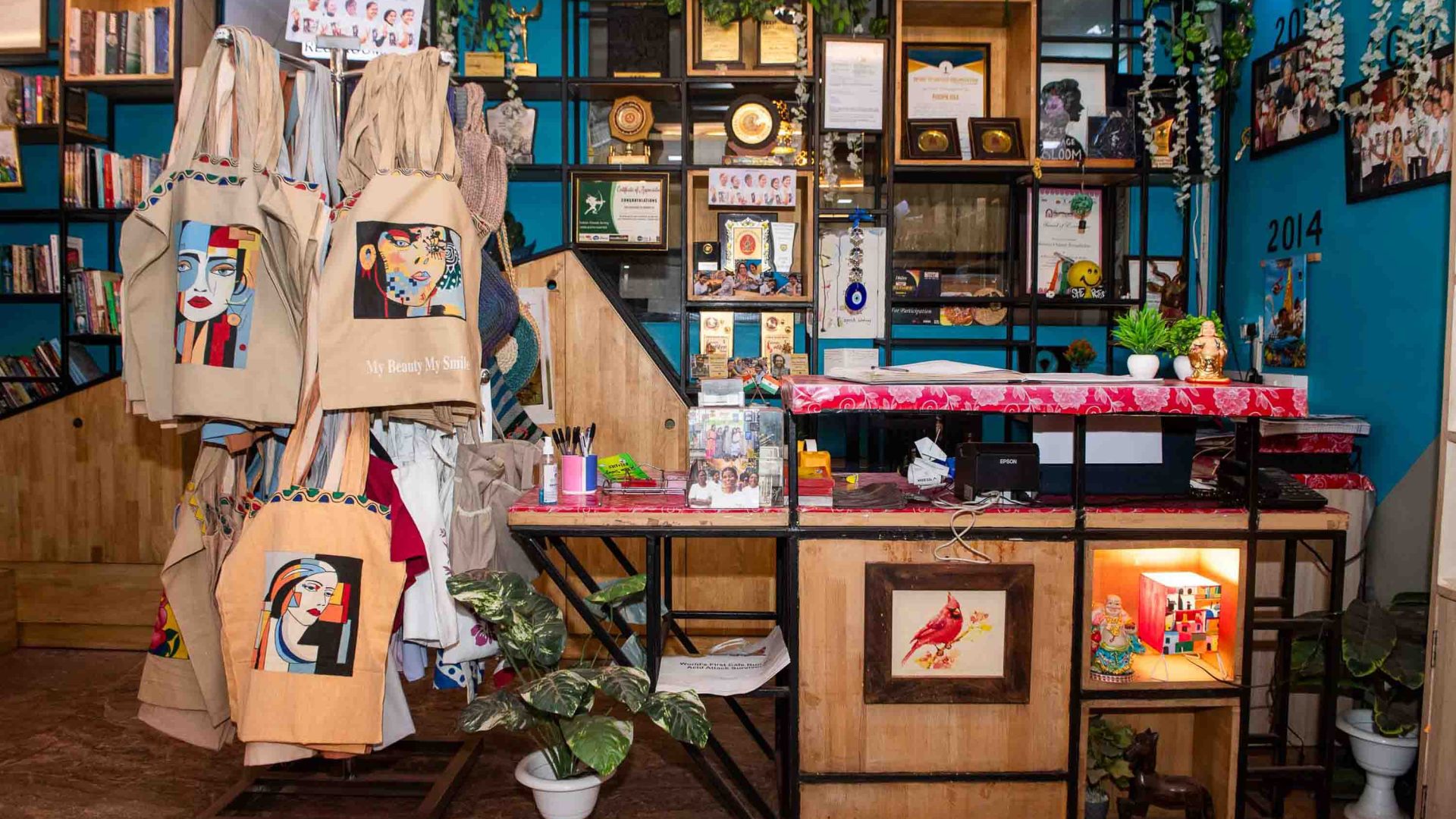 The inside of a cafe which shows things for sale including books and bags.