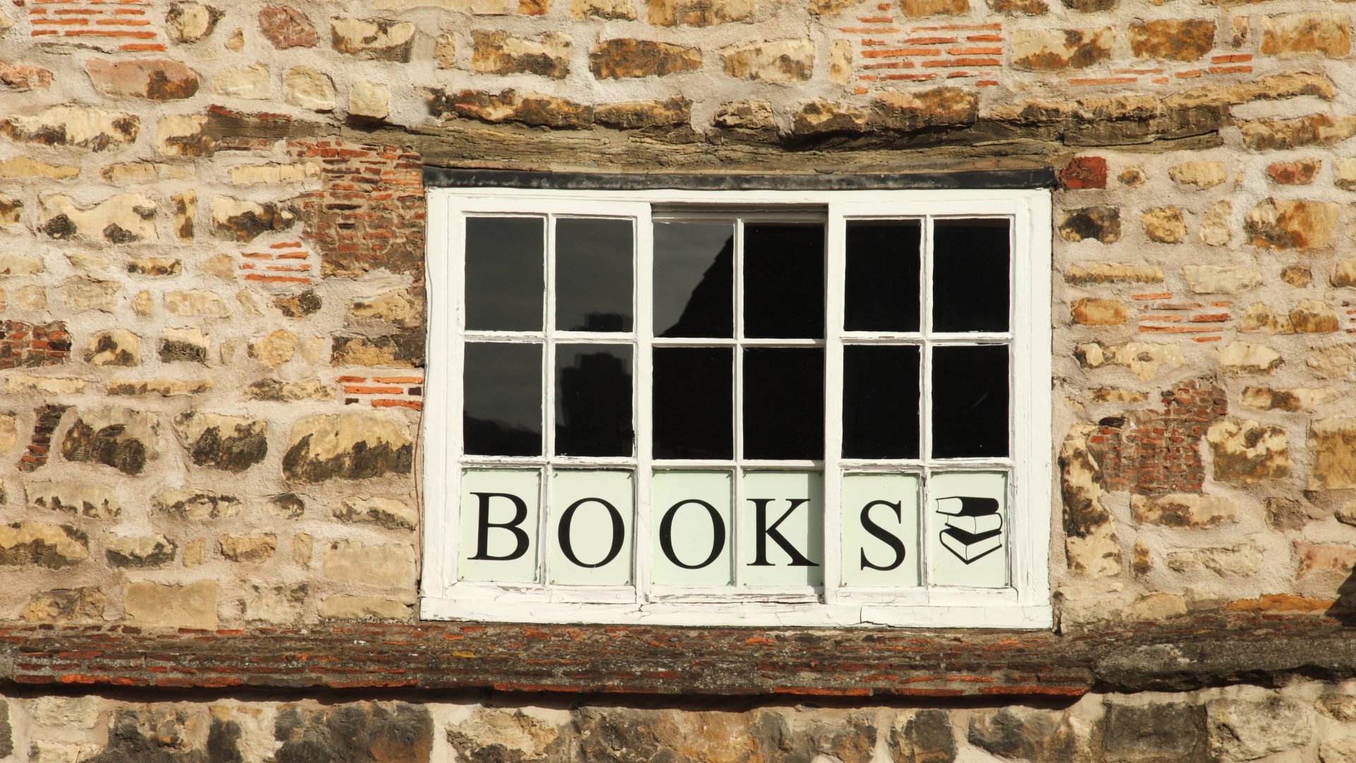 Stone building with window sign reading 'BOOKS;.