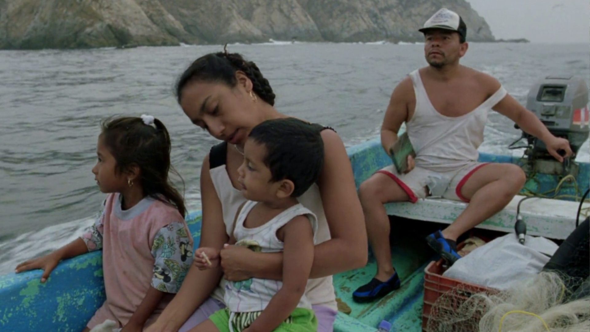 A family of four sit on a blue boat.