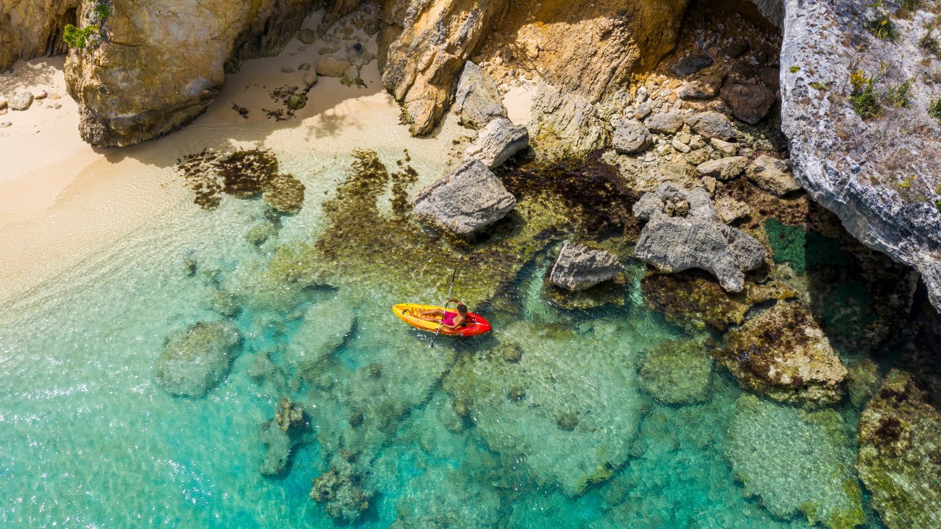 Birds-eye view of red kayak in blue water