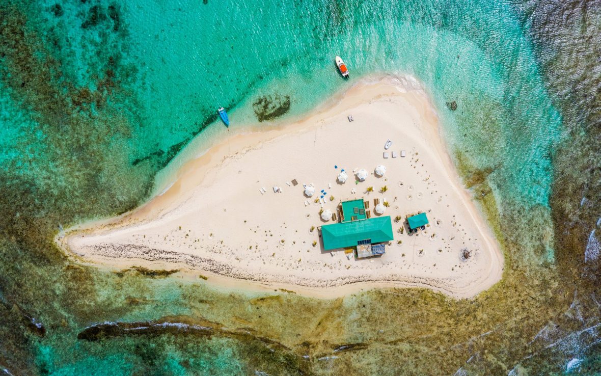 White sand island surrounded by blue water.