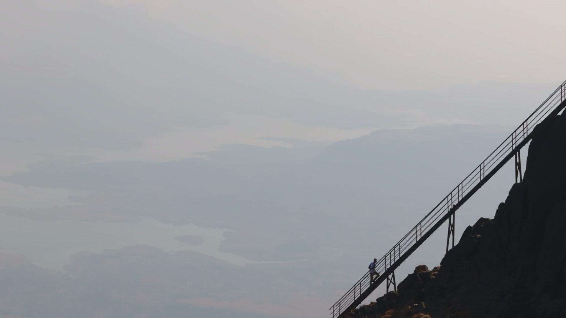 Silhoutte of staircase against gray sky.