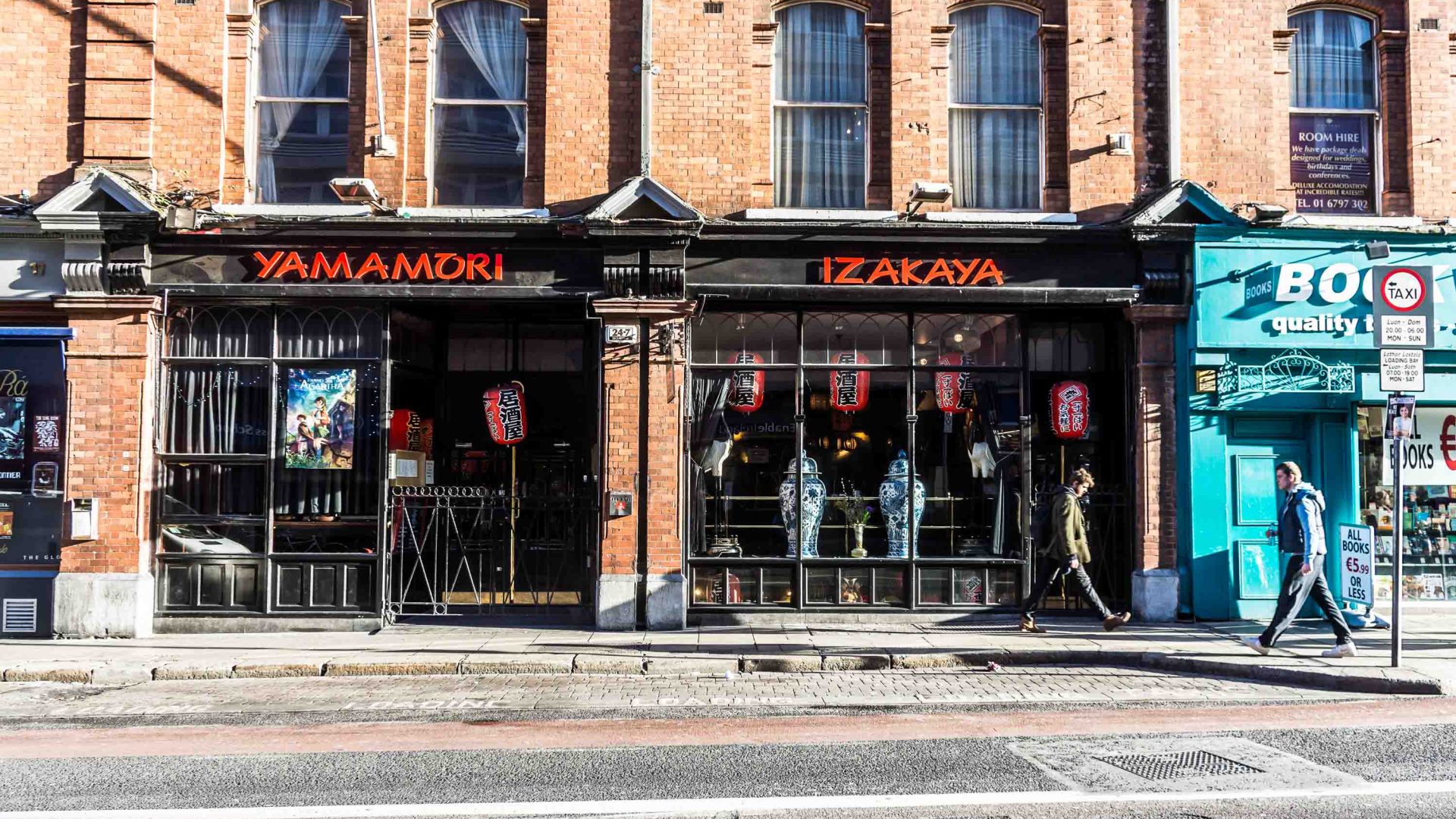 The black exterior of a venue with red font with the name Yamamori Izakaya.