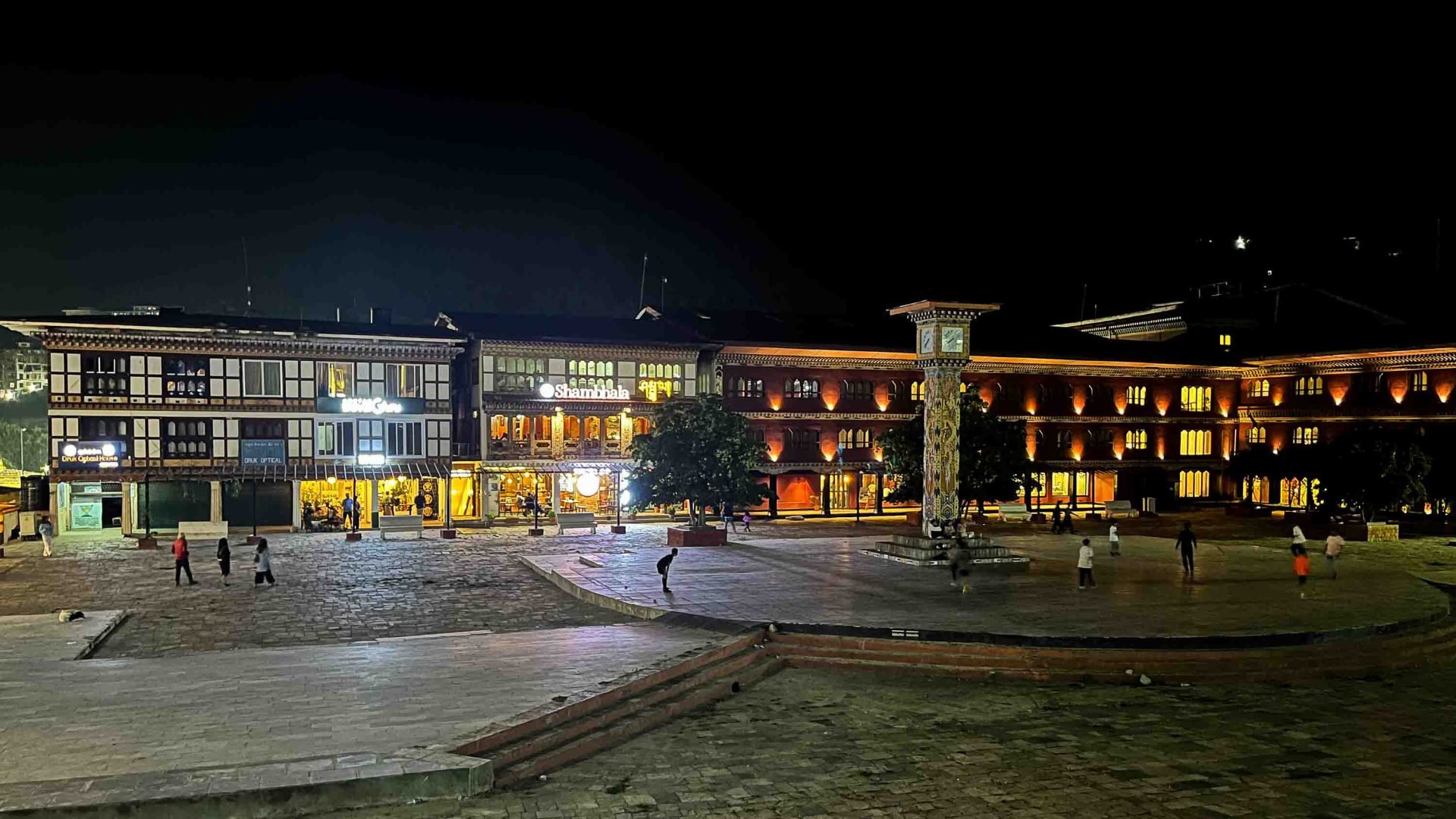 A clocktower and buildings at night.